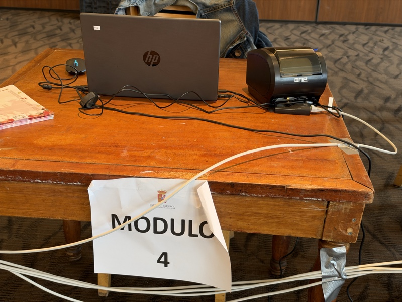 Puesto de atención con notebook, impresora y cableado de red.
